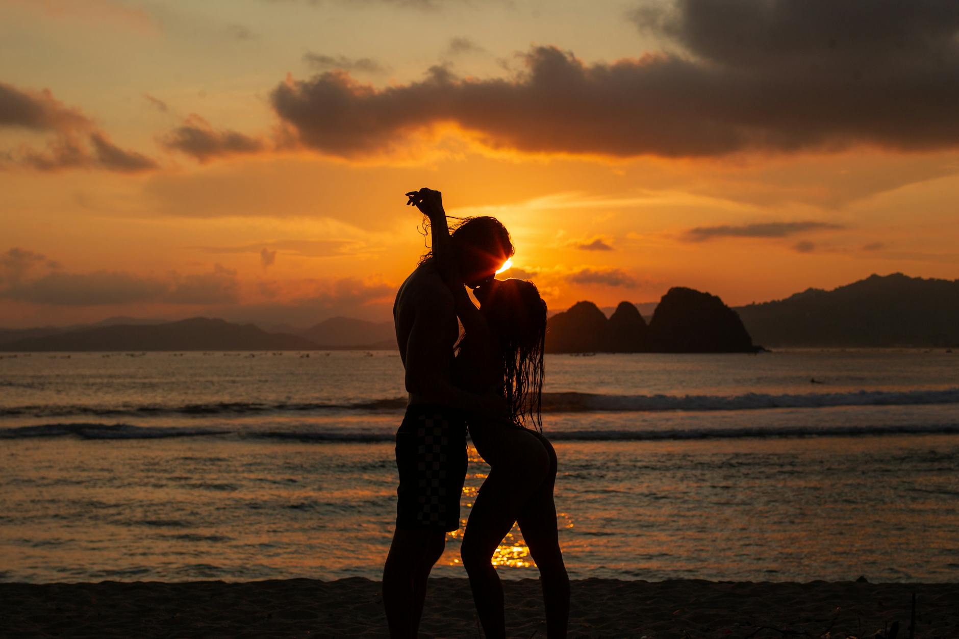 silhouette of kissing couple on beach